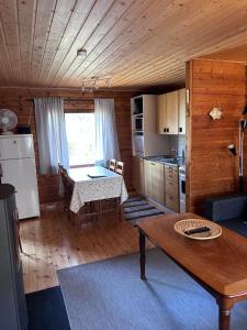 a kitchen and dining room with a table in a cabin at Herrö stugor in Lemland