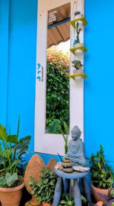 a buddha statue sitting on a table in front of a mirror at Casa Swell Hostel in Fernando de Noronha