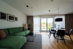 a living room with a green couch and a table at Noas Bergisel in Innsbruck