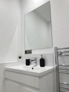 a white bathroom with a sink and a mirror at The Studio Room in Brentwood