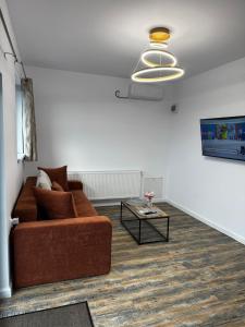 a living room with a brown couch and a table at Escape in Ghelar