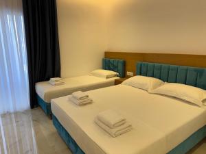 two beds in a hotel room with towels on them at Sorean HOTEL in Ksamil