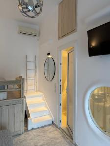 a room with stairs and a tv and a mirror at Starlight Luxury Studios in Mikonos