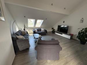 a living room with couches and a flat screen tv at Ferienwohnung am Flughafen in Braunschweig