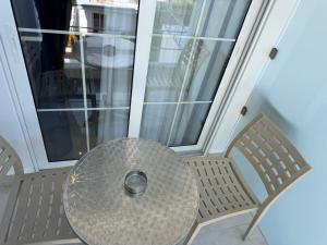 a table and chairs on a porch with a window at Sorean HOTEL in Ksamil