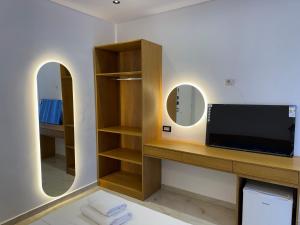 a bathroom with a tv and a mirror at Sorean HOTEL in Ksamil