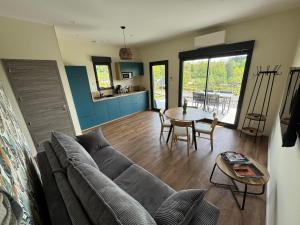 a living room with a couch and a table at Pétalya Lodge in Montcornet