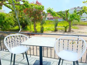 two chairs and a table on a balcony at Κωνσταντίνος Έλενα Studios in Pefki