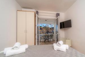a bedroom with a bed with white towels on it at Apartments Gurman in Rab