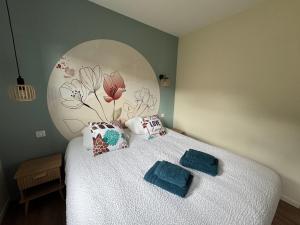 a bedroom with a bed with two pillows on it at Pétalya Lodge in Montcornet