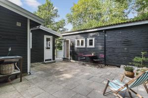 a patio with a table and chairs next to a house at 1607-Vejby-Laerkebakken-8 in Vejby