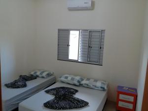 2 camas individuales en una habitación con ventana en Atlantico Residencial, en Bonito