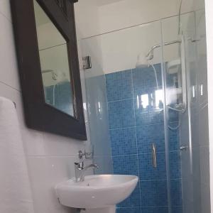 a bathroom with a sink and a shower with a mirror at AZUL PUERTO Del MALECON in San Felipe de Puerto Plata +27 photos