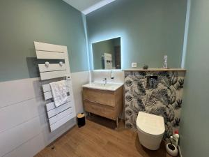a bathroom with a sink and a toilet and a mirror at Pétalya Lodge in Montcornet +19 photos