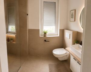 a bathroom with a shower and a toilet and a sink at StayIN Suites in Griesheim +16 photos