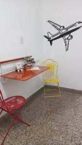 a desk and a chair with a plane on the wall at Día y noche in Ezeiza +2 photos