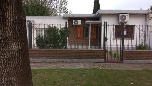 a house with a gate and a fence at Día y noche in Ezeiza