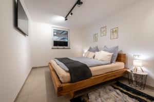 a bedroom with a bed with a wooden frame at Ferienhaus Goldener Anker Unterach am Attersee in Unterach am Attersee