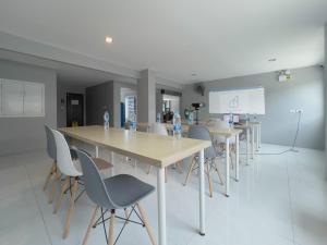 a conference room with tables and chairs and a screen at Toyatsu Residence in Pathum Thani