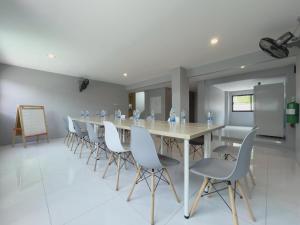 a long dining room with a long table and chairs at Toyatsu Residence in Pathum Thani