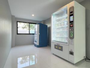 an empty kitchen with an empty refrigerator and a window at Toyatsu Residence in Pathum Thani
