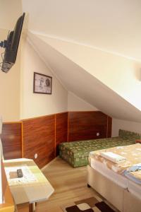 a attic room with two beds and a table at Cserki Panzió Balatonfőkajár in Balatonfőkajár +21 photos