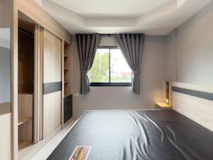 a bedroom with a bed and a window at Toyatsu Residence in Pathum Thani +56 photos