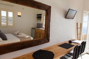 a bedroom with a large mirror on the wall at Astarte Sifnos in Artemonas