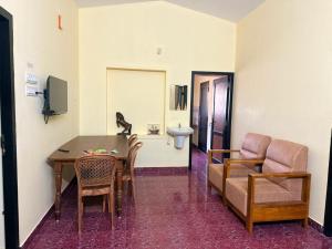 a living room with a table and chairs and a sink at Bluebell Homes Near Beypore Beach Kozhikode in Kozhikode