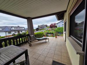 a porch with a bench and a balcony with a view at Ferienwohnung Sonnenberg am Radweg in Gedern