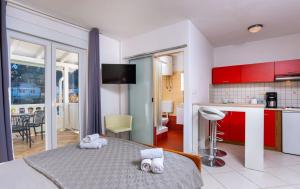 a bedroom with a bed and a kitchen with red cabinets at Apartments Gurman in Rab +203 photos