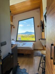 a room with a bed and a large window at DANGUBA - Tiny Glamp House With Hot Tub by IGLENA in Kupres