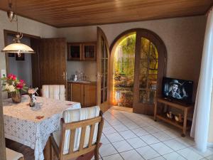 a kitchen with a table and a tv in a room at Ferienwohnung Sonnenberg am Radweg in Gedern