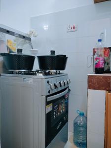 a kitchen with two pots on top of a stove at Cutie coastal studios in Bamburi