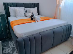 a large bed with a blue headboard in a room at Cutie coastal studios in Bamburi