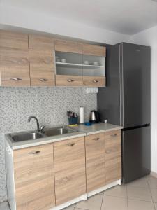a kitchen with wooden cabinets and a black refrigerator at Phoenix - Rise and Relax in Agia Galini