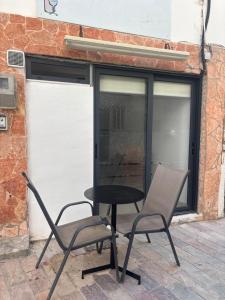 a table and two chairs in front of a garage at Phoenix - Rise and Relax in Agia Galini