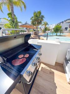 a grill on a balcony with two hamburgers on it at Luxury Costa Blanca Villa near Denia with pool and roof terrace in El Verger