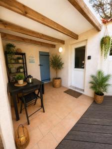 a patio with a table and two potted plants at Charmant studio avec piscine 4 personnes in Fréjus