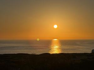 a sunset over the ocean with the sun in the sky at Villa Miramar Vistas espectaculares in Es Mercadal