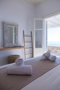 a bedroom with a bed with towels on it at Astarte Sifnos in Artemonas +122 photos