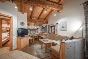 a living room with a couch and a tv at Bergbauernhof Simmerl in Sachrang