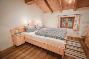 a bedroom with a large bed with a wooden headboard at Bergbauernhof Simmerl in Sachrang