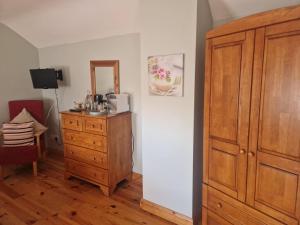 a room with a wooden cabinet and a dresser at Dee's Nest in Dingle +5 photos
