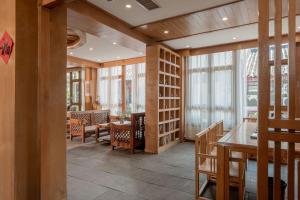a dining room with tables and chairs and windows at Lijiang Cloud Return Huiyi · On the Water Side Panoramic Hidden Inn (South Gate Mufu Branch) in Lijiang