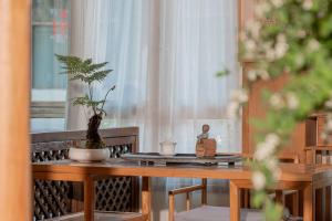 a wooden table with two plants on top of it at Lijiang Cloud Return Huiyi · On the Water Side Panoramic Hidden Inn (South Gate Mufu Branch) in Lijiang
