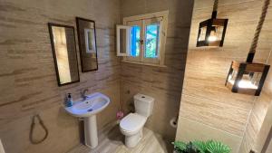 a bathroom with a white toilet and a sink at Caribiano villa-3 in Dawwār Ḩalīs