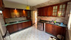 a kitchen with wooden cabinets and a brick wall at Caribiano villa-3 in Dawwār Ḩalīs +23 photos