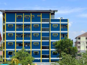 a blue and yellow building with trees in front of it at Toyatsu Residence in Pathum Thani