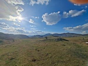 a view of a field with the sun in the sky at Autocamp Kotari in Plužine